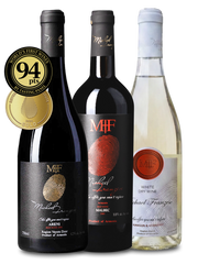 Three wine bottles with labels and a gold medal on a white background